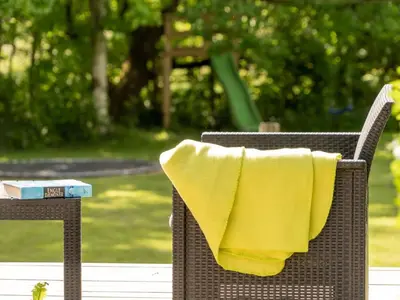a yellow towel is sitting on a wicker chair at Holiday Home Bjerne - 250m to the fjord by Interhome in Roslev