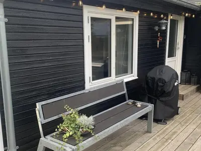 a bench sitting on the porch of a house at Holiday Home Bjerne - 250m to the fjord by Interhome in Roslev