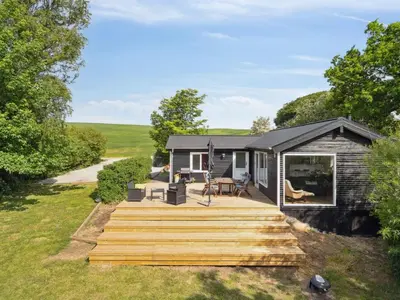 a cabin with a wooden deck next to a yard at Holiday Home Bjerne - 250m to the fjord by Interhome in Roslev