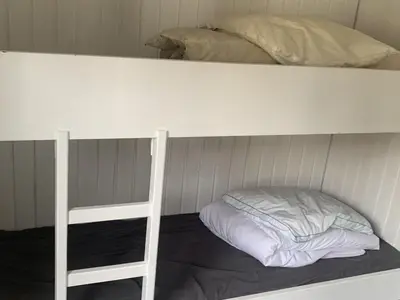 a bunk bed with a pillow on the bottom bunk at Holiday Home Bjerne - 250m to the fjord by Interhome in Roslev