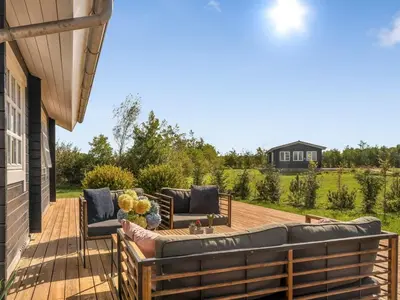 a patio with a couch and chairs on a deck at Holiday Home Gizella - 500m to the fjord by Interhome in Spottrup