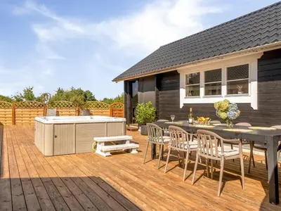 a deck with a grill and a table and chairs at Holiday Home Gizella - 500m to the fjord by Interhome in Spottrup