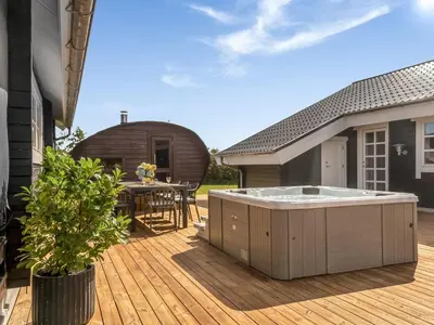 a wooden deck with a hot tub on a house at Holiday Home Gizella - 500m to the fjord by Interhome in Spottrup