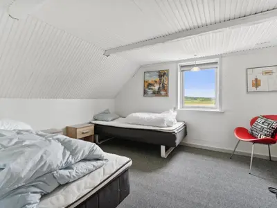 a bedroom with a bed and a window and a chair at Holiday Home Swaantje - 150m to the fjord by Interhome in Fur