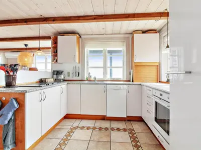 a kitchen with white cabinets and white appliances at Holiday Home Sander - 10m to the fjord by Interhome in Roslev