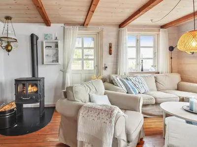 a living room with a couch and a wood stove at Holiday Home Sander - 10m to the fjord by Interhome in Roslev
