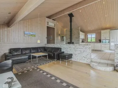 a large living room with a couch and a kitchen at Holiday Home Ran - 1-5km from the sea by Interhome in Saltum