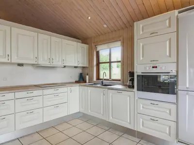 a white kitchen with white cabinets and a window at Holiday Home Ran - 1-5km from the sea by Interhome in Saltum