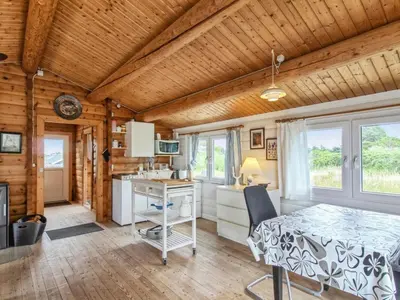 a kitchen with a table and a desk in a room at Holiday Home Sampo - 400m from the sea by Interhome in Løkken
