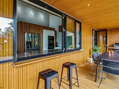 a room with two stools and a table and some windows at Holiday Home Bena - 800m from the sea by Interhome in Blokhus