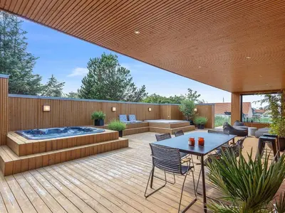 a patio with a hot tub and a table and chairs at Holiday Home Bena - 800m from the sea by Interhome in Blokhus