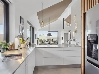 a kitchen with white cabinets and a living room at Holiday Home Bena - 800m from the sea by Interhome in Blokhus