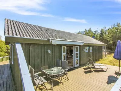 a house with a deck with a table and chairs at Holiday Home Gerasim - 1km from the sea by Interhome in Saltum