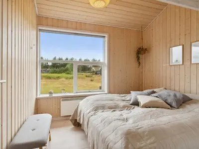 a bedroom with a large bed and a large window at Holiday Home Sazdo - 1-1km from the sea by Interhome in Saltum