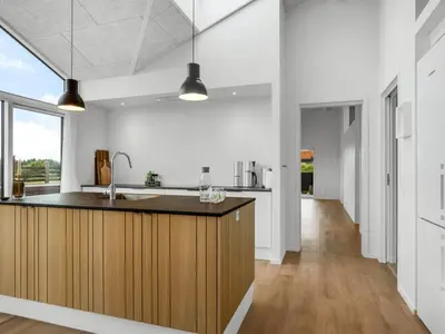 a kitchen with white walls and a wooden counter top at Holiday Home Egil - 1-5km from the sea by Interhome in Saltum