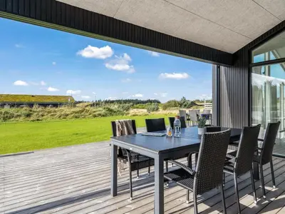 a patio with a table and chairs on a deck at Holiday Home Egil - 1-5km from the sea by Interhome in Saltum