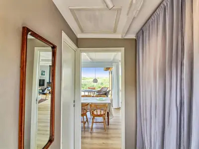 a hallway with a mirror and a dining room at Holiday Home Hoat - 300m from the sea by Interhome in Saltum