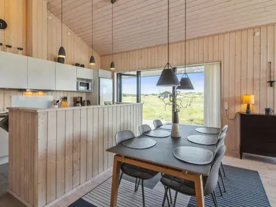 a kitchen and dining room with a table and chairs at Holiday Home Ascan - 600m from the sea by Interhome in Løkken