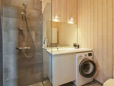a bathroom with a washing machine and a sink at Holiday Home Ascan - 600m from the sea by Interhome in Løkken