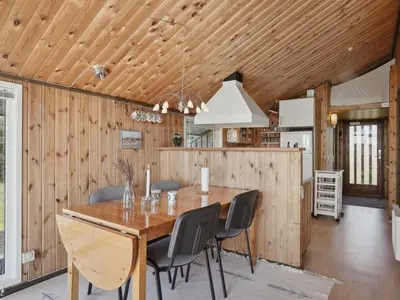 a dining room and kitchen with a wooden ceiling at Holiday Home Tianna - 500m from the sea by Interhome in Pandrup