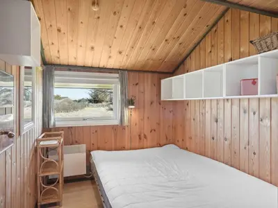 a bedroom in a tiny house with a bed at Holiday Home Tianna - 500m from the sea by Interhome in Pandrup