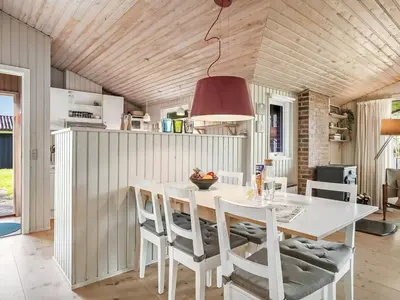 a kitchen with a white table and chairs at Holiday Home Apsolon - 600m from the sea by Interhome in Løkken