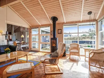 a living room with a fireplace and a table and chairs at Holiday Home Franzisca - 700m from the sea by Interhome in Saltum