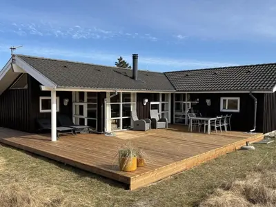 a house with a wooden deck in front of it at Holiday Home Franzisca - 700m from the sea by Interhome in Saltum