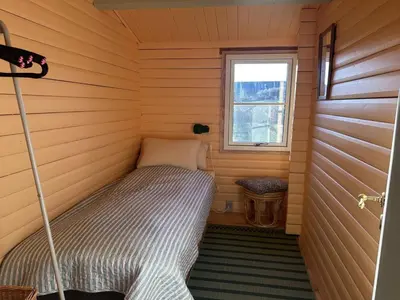 a small bed in a room with a window at Holiday Home Freding - 450m from the sea by Interhome in Løkken