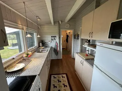 a kitchen with white cabinets and a counter top at Holiday Home Freding - 450m from the sea by Interhome in Løkken