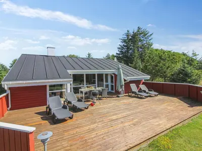 a wooden deck with chairs and a house at Holiday Home Valda - 1-5km from the sea by Interhome in Saltum