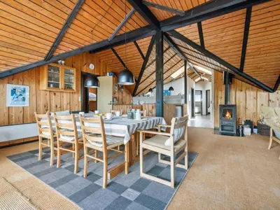 a dining room with a table and chairs and a fireplace at Holiday Home Henri - 500m from the sea by Interhome in Fjerritslev