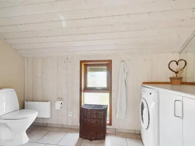 a bathroom with a toilet and a washing machine at Holiday Home Henri - 500m from the sea by Interhome in Fjerritslev