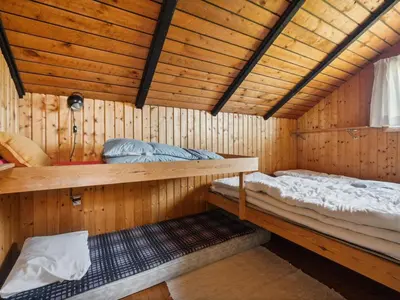 a room with two bunk beds in a wooden cabin at Holiday Home Henri - 500m from the sea by Interhome in Fjerritslev
