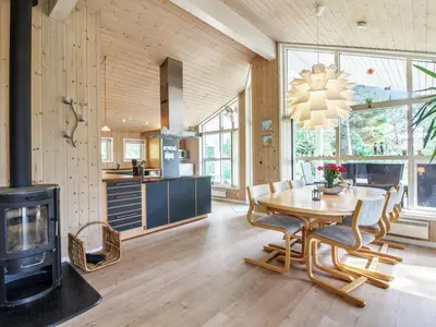 a kitchen and dining room with a table and a fireplace at Holiday Home Arlett - 950m from the sea by Interhome in Fjerritslev