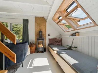 a room with a couch and a fireplace in a tiny house at Holiday Home Nadia - 300m to the fjord by Interhome in Fur