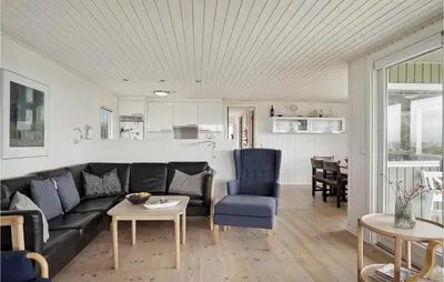a living room with a couch and a table at Awesome Home In Løkken in Løkken