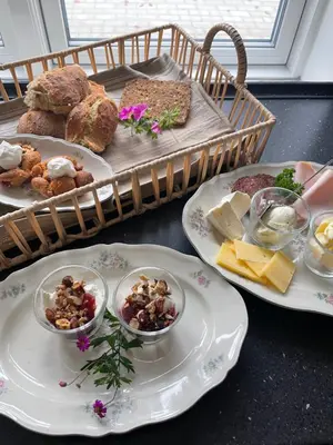 a table with two plates of food and a tray of bread at Thyholm B&B in Thyholm