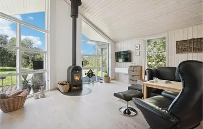 a living room with a fireplace and a table and chairs at Amazing Home In Vestervig With Kitchen in Vestervig
