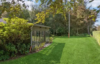 a garden with a wooden fence in the grass at Awesome Home In Nykøbing M in Hesselbjerg