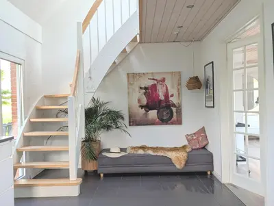 a living room with a staircase and a couch at Villa Vandkant in Thyholm