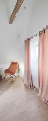 a room with pink curtains and a chair next to a window at Villa Vandkant in Thyholm