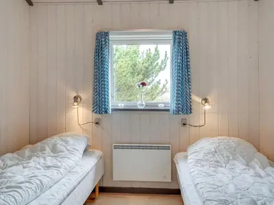two beds in a room with a window at Holiday Home Floria - 1-4km from the sea by Interhome in Torsted