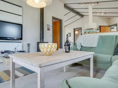 a living room with a table with a bottle of wine at Holiday Home Floria - 1-4km from the sea by Interhome in Torsted