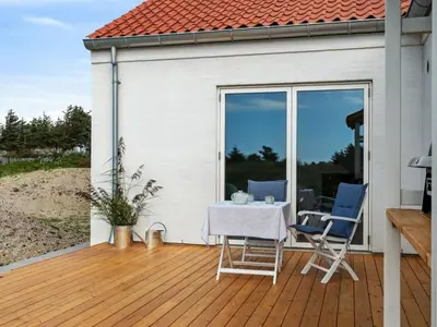 a patio with a table and chairs on a deck at Holiday Home Yakari - 1km from the sea by Interhome in Torsted