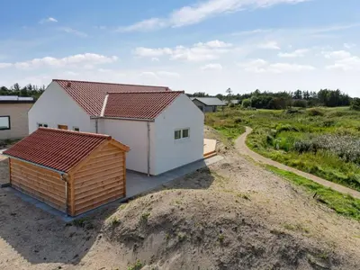 a small white house with a red roof on a dirt road at Holiday Home Yakari - 1km from the sea by Interhome in Torsted