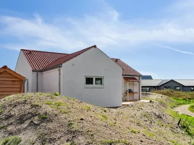 a white house on top of a dirt hill at Holiday Home Yakari - 1km from the sea by Interhome in Torsted