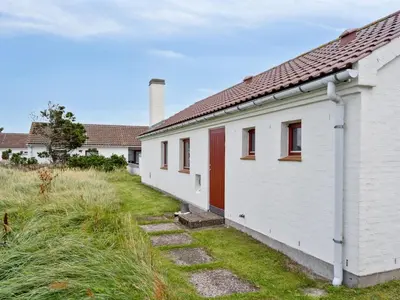 a row of white houses with red doors at Holiday Home Werna - 900m from the sea by Interhome in Pandrup