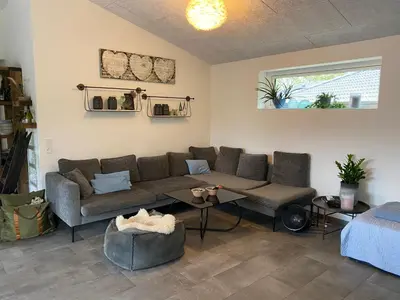 a living room with a couch and a table at Hyggeligt hus. in Holstebro