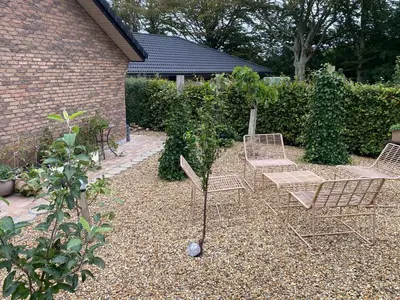 a group of chairs and tables in a garden at Hyggeligt hus. in Holstebro